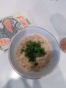 A bowl of fonio and mushrooms with parsley on top.