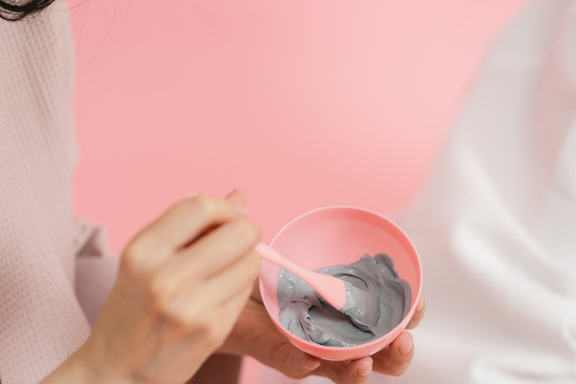 womans hand mixing bentonite clay for armpit detox mask recipe